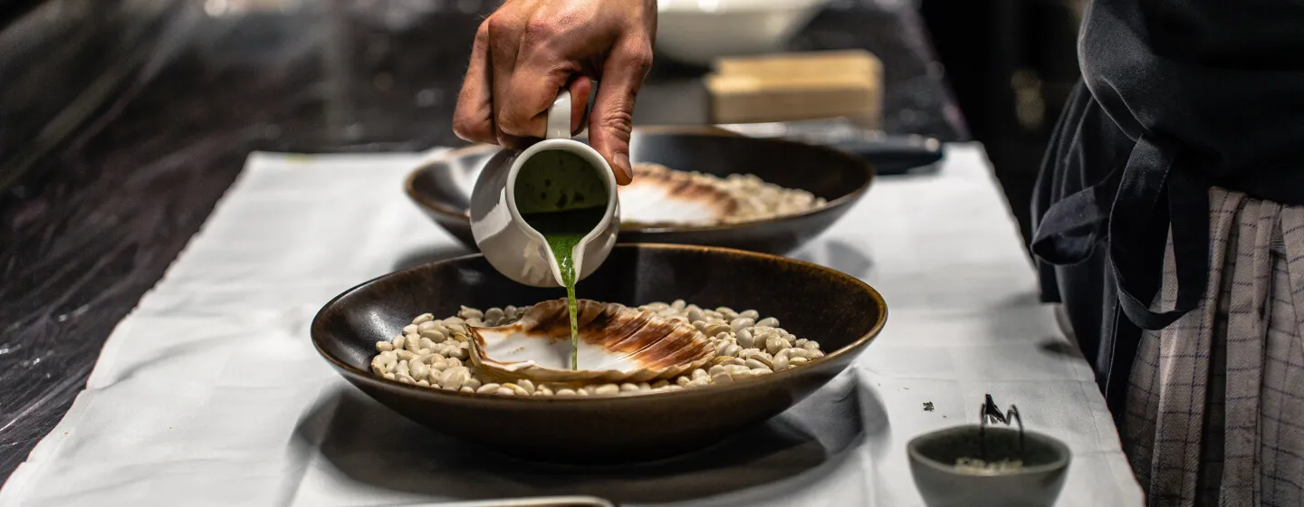 Kokk heller saus i et kamskjell