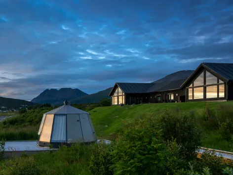 Lyngen Experience Lodge, and glass iglo, during a summer evening