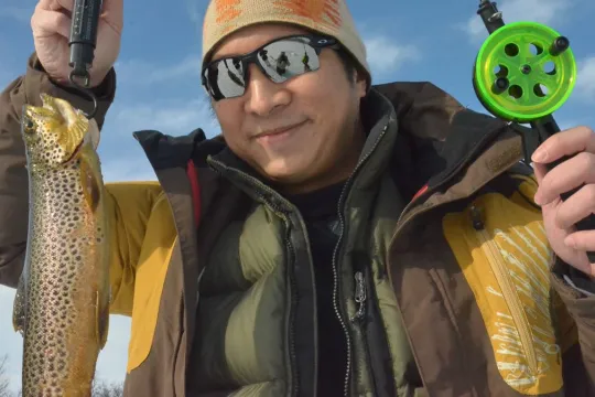 A guest holding a fish they have caught