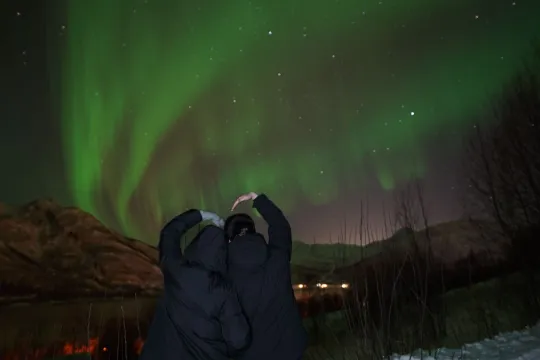 Two guests looking a the northern lights