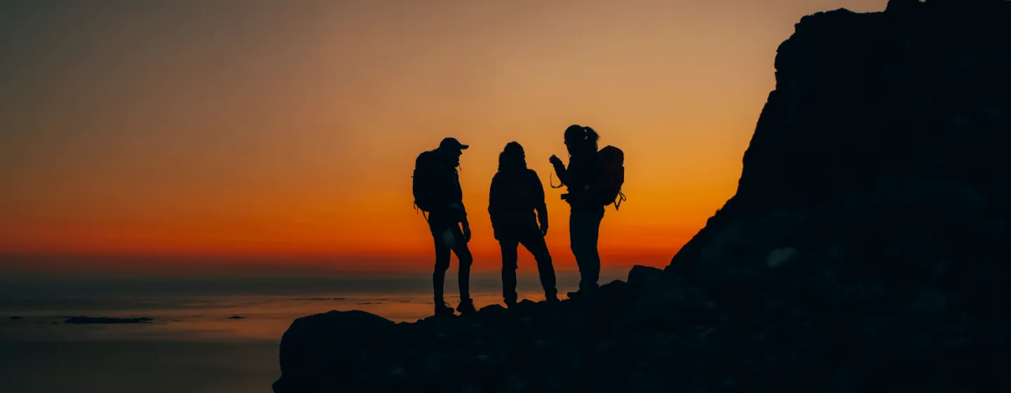 Siluetter på en fjelltopp i solnedgang