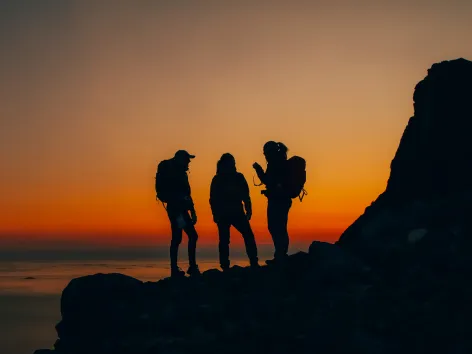 Siluetter på en fjelltopp i solnedgang